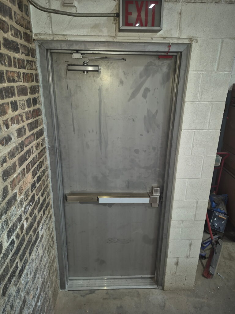 Commercial steel door with push bar and door closer installed by Omega Locksmith